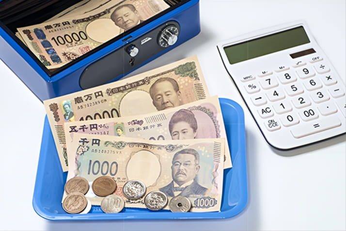 現金と電卓が並ぶ金庫の様子
